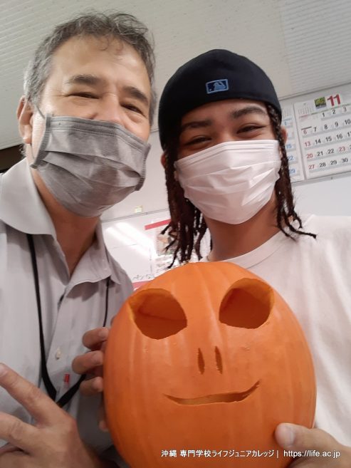 一般学生がハロウィンのジャック・オー・ランタンを彫る!! Carving a Jack-o'-lantern!! 🎃
ENGLISH CONTENT:
Carving a Jack-o'-lantern!! 🎃
The General Students at Vocational School LIFE Jr College had a special class activity on October 31st (Halloween). Their homeroom teacher, Mark Pickard, bought an orange pumpkin and taught the general students how to carve a Halloween Jack-o'-lantern. Orange pumpkins are quite rare in Okinawa, but Mark-teacher was able to buy one. Mark-sensei is an American. This was the very first time for the General Students to carve a Jack-o'-lantern for Halloween. The students decided to carve the face for an alien for the Halloween Jack-o'-lantern. The students worked hard and did a terrific job! As you can see in the photographs, their Alien Jack-o'-lantern looks awesome! The General Students had a good time while also experiencing some American culture. The Jack-o'-lantern will be on display at the 2022 Happy Halloween Party. The Happy Halloween Party is a Special English Class at Vocational School LIFE Jr College.
Visit our Facebook Page and Instagram account to see even more photographs. Please use the links below.
Facebook Page: https://www.facebook.com/LifeJrCollege
Instagram Account: https://www.instagram.com/lifejrcollege
They isn't a better place in Okinawa than LIFE Jr College Vocational School to learn the English language and to experience foreign cultures. Vocational School LIFE Jr College is an accredited two-year post-secondary academic institution located in Naha City, Okinawa Prefecture. You should be a student together with us at Vocational School LIFE Jr College!